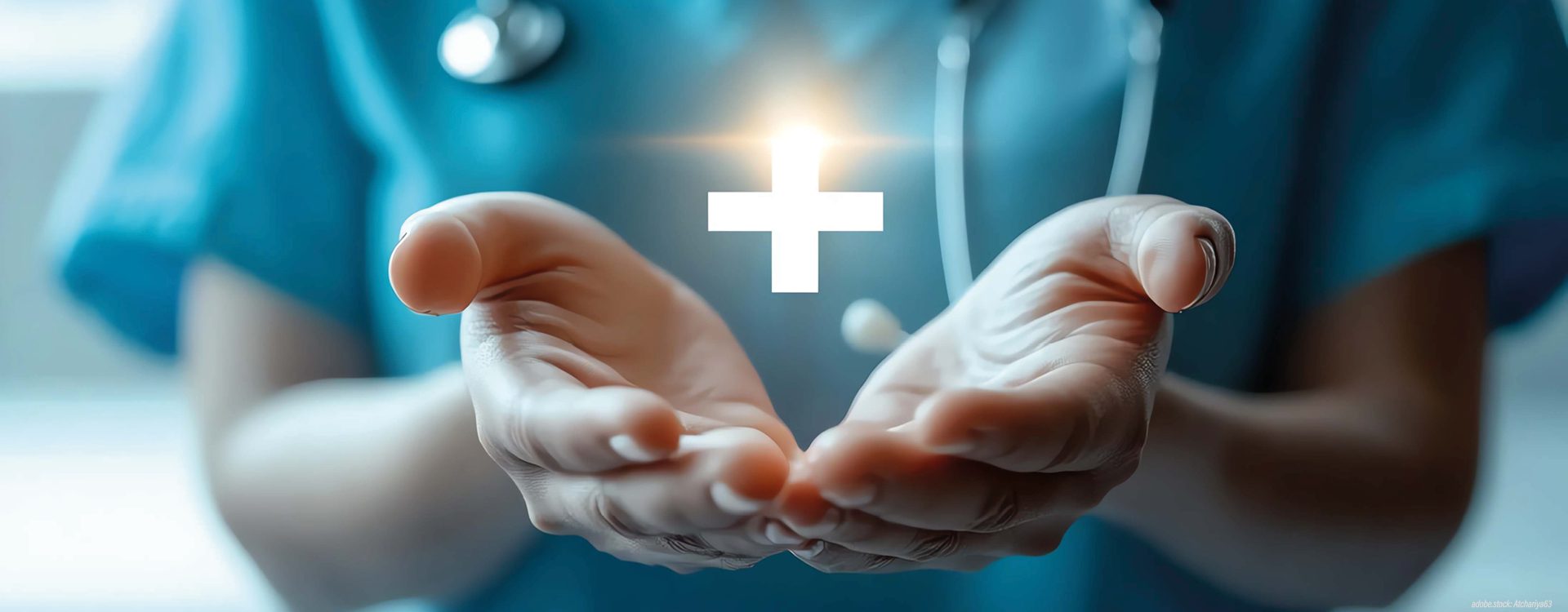 Zwei Hände einer medizinischen Fachkraft präsentieren ein strahlendes Kreuz