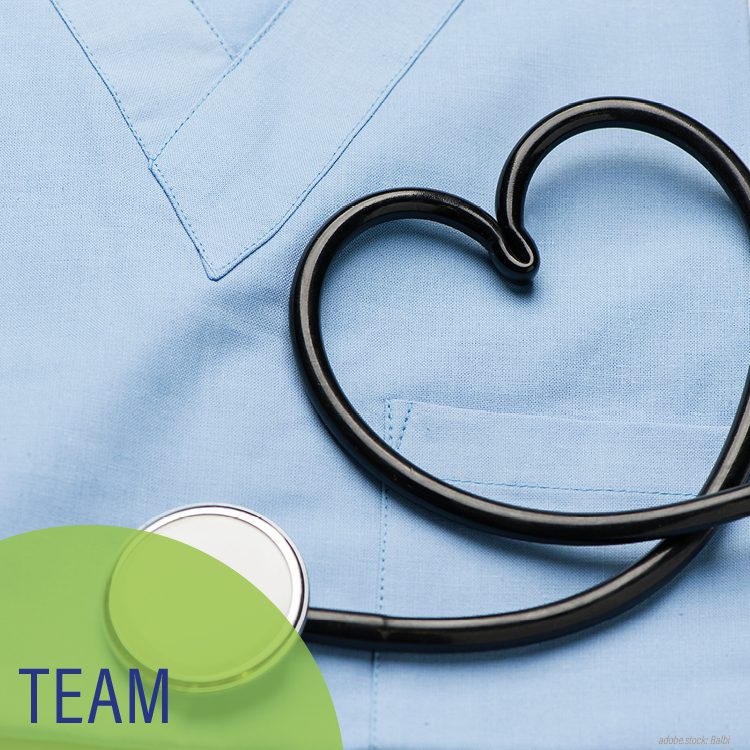 zu einem Herz geformtes Sthetoskop vor einem hellblauen Krankenhauskasack, hellgrüner Kreis mit der Aufschrift Team