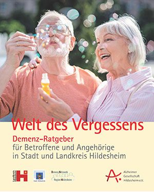 Älteres Paar mit Seifenblasen auf der Broschüre Demenzratgeber